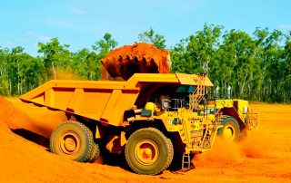 Bauxite is being loaded to haul truck by using excavator